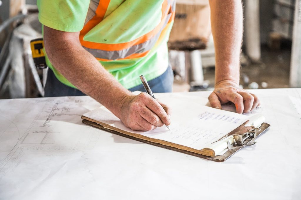 : A surveyor writing notes on a clipboard