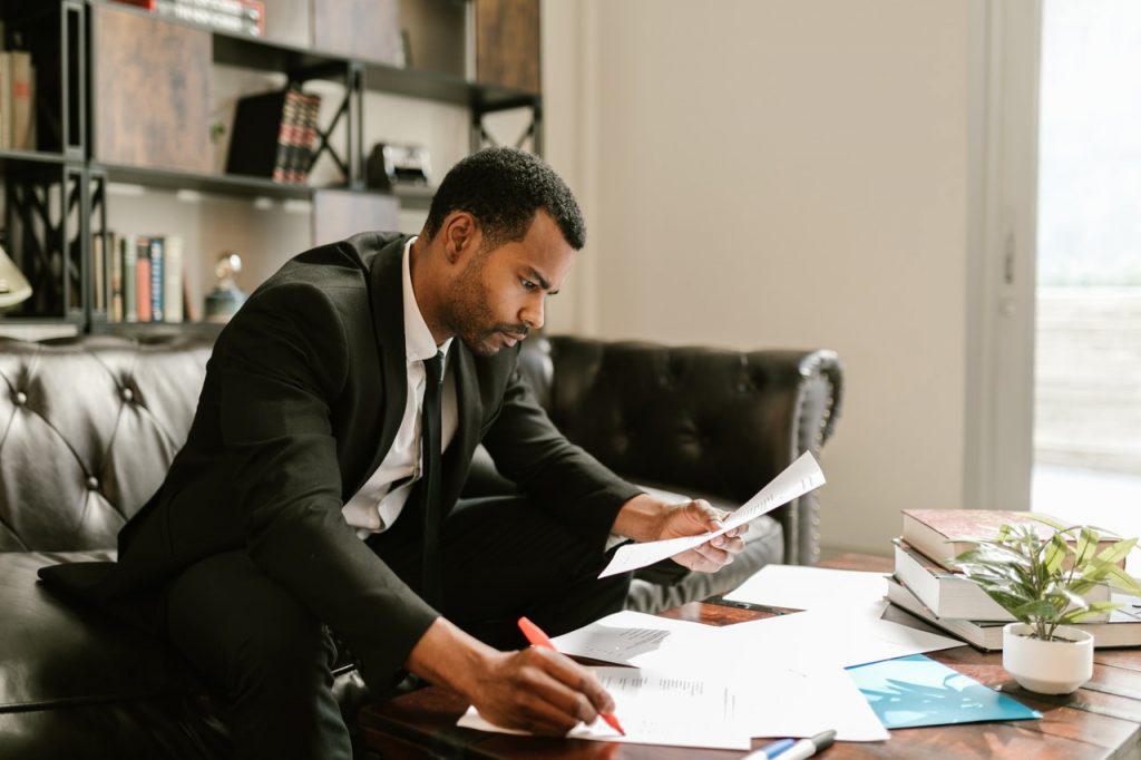 Man in Black Suit Writing on White Paper