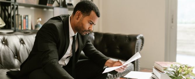 Man in Black Suit Writing on White Paper