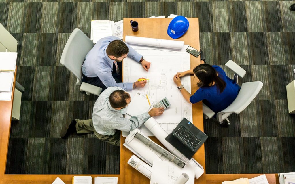 three people sitting down in a table 