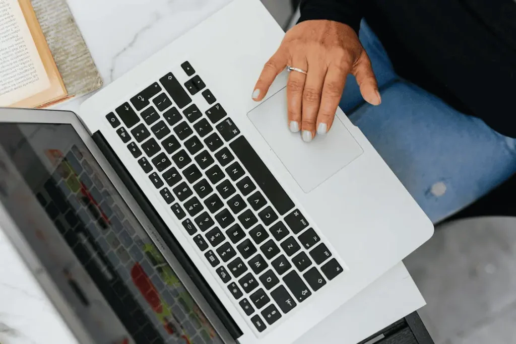 Person Using Macbook on White Table